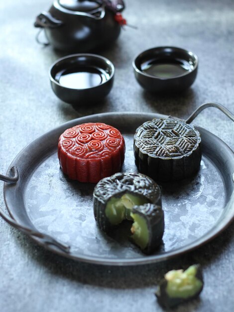 Foto hoge hoek van traditionele rode en zwarte mooncake op de ruwe grijze textuur tafel