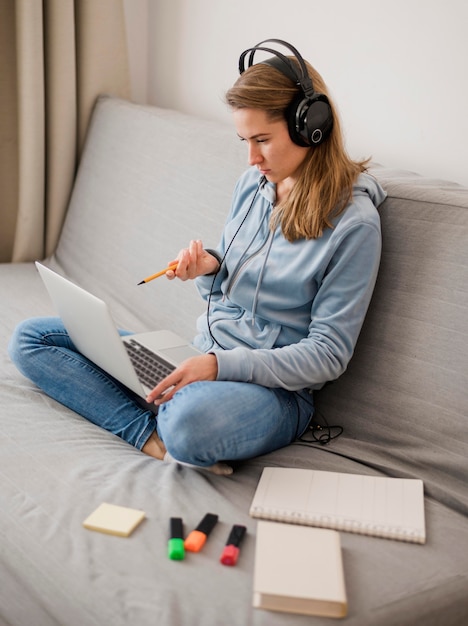 Foto hoge hoek van vrouw die op laag een online klasse door laptop bijwoont