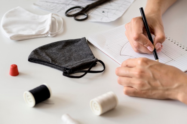 Foto hoge hoek van vrouw die te naaien gezichtsmasker ontwerpt