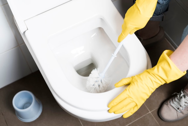 Foto hoge hoek van vrouw schoonmaak toilet