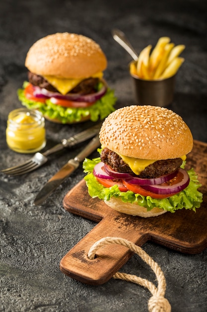 Hoge hoek verse hamburgers op snijplank met frietjes