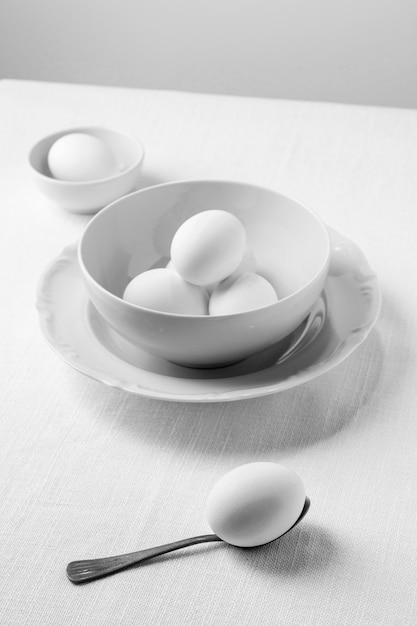 Foto hoge hoek witte eieren in kom en theelepel