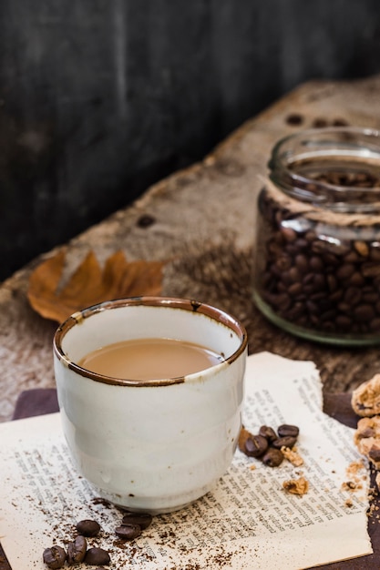 Hoge hoekkoffie met melk en koffiebonenkruik