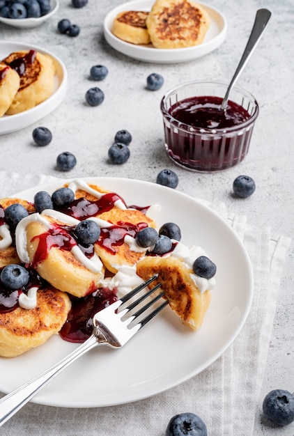 Hoge hoekmening van cottage cheese pannenkoeken met zure room bosbessenjam en bosbessen