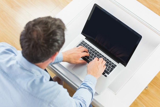 Hoge hoekmening van de toevallige mens die laptop met behulp van