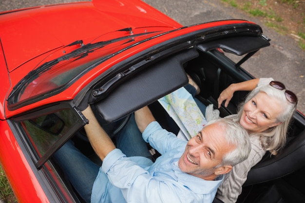 Hoge hoekmening van de vrolijke rijpe mens die een rit met zijn vrouw heeft