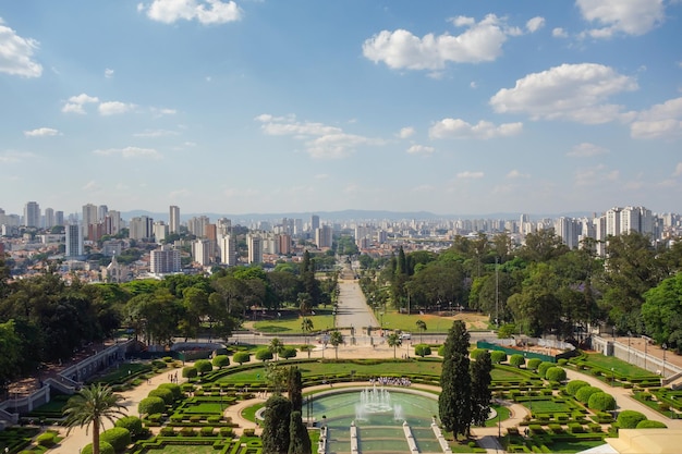 hoge hoekmening van Ipiranga Museum tuin en fonteinen met Sao Paulo stadsgezicht als achtergrond, Brazilië