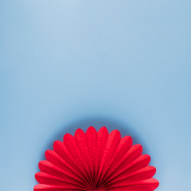 Foto hoge hoekmening van rode mooie origamibloem op blauwe achtergrond