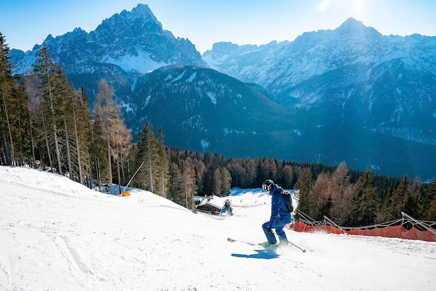 Hoge hoekmening van skiër skiën op helling tegen bergketen