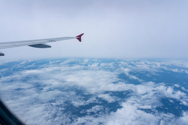 Hoge hoekmening van venster van vliegtuig mooie hemel en witte wolken