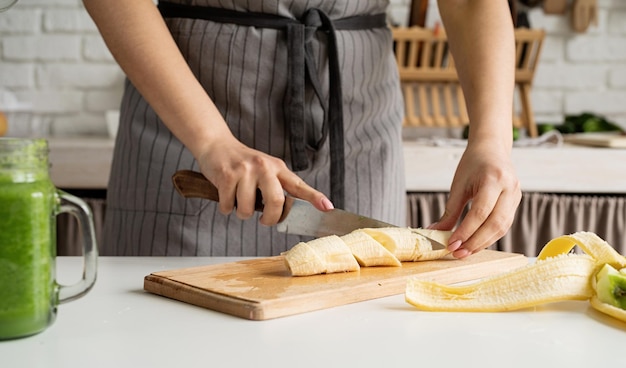 Hoge hoekmening van vrouwelijke handen die banaan snijden