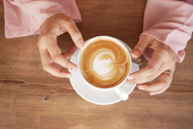 Hoge hoekmening van vrouwen die koffiekopje houden