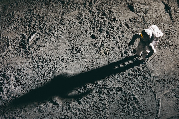 Hoge hoekopname van een miniatuurspeelgoed van een astronaut op de maan