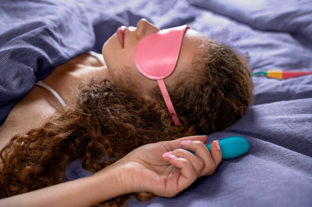 Foto hoge hoekvrouw met vibrators en ogenmasker