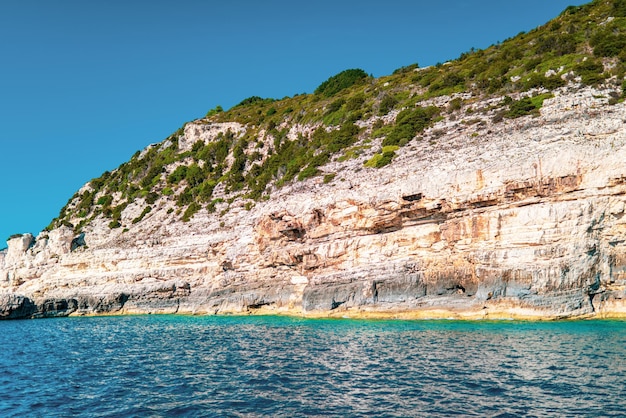 Hoge kliffen met bos en rotsen aan de kust van het eiland Corfu