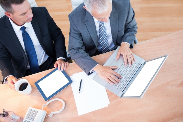 Hoge mening van zakenlieden die aan laptop samenwerken