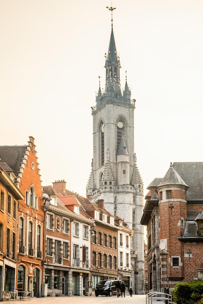 Hoge middeleeuwse klokkentoren die boven de straat uitsteekt met oude Europese huizen Doornik Waalse gemeente België