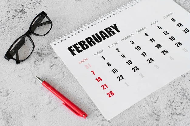 Foto hoge weergave briefpapier kalender februari maand en leesbril