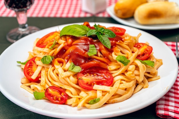 Hoge weergave van een bord spaghetti pasta met een heerlijke tomatensaus met huisgemaakte basilicumblaadjes