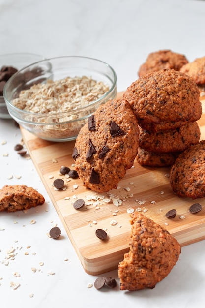 Hoge weergave van zelfgemaakte haverkoekjes met chocolade Gezond ontbijt geserveerd op een houten bord