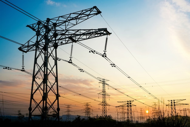 Hogedrukkabel toren bij zonsondergang in de schemering