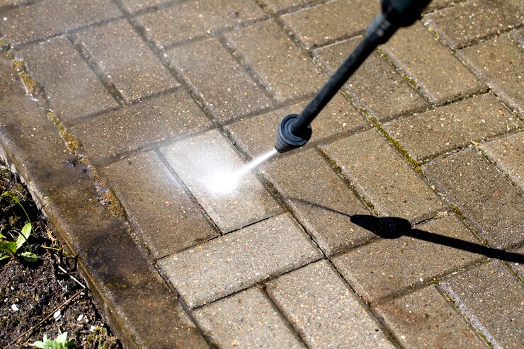 Hogedrukreiniger reinigt met waterstraal de betonnen vloer
