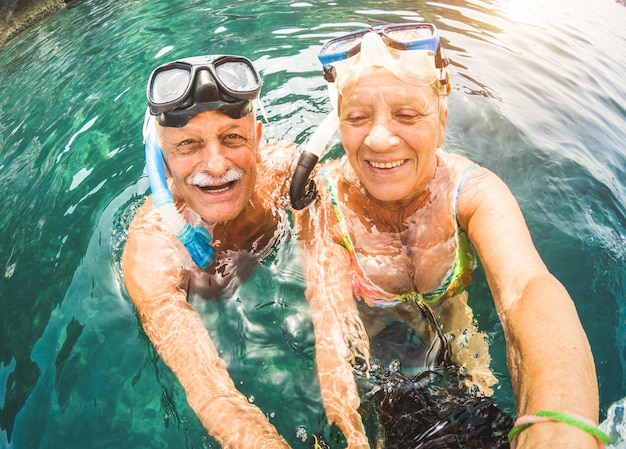 Hoger paar dat pret heeft die bij tropisch strand snorkelt