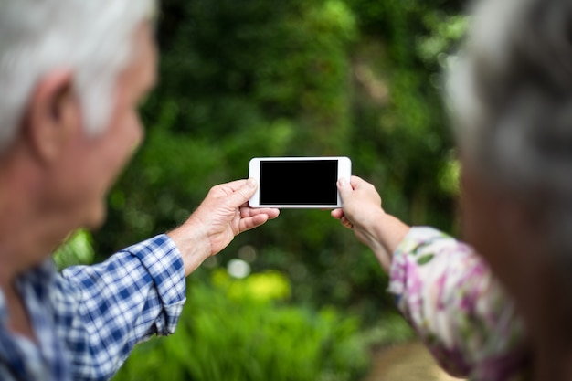 Hoger paar die selfie in achtertuin nemen