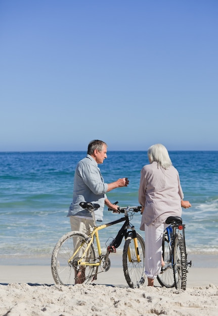 Hoger paar met hun fietsen op het strand