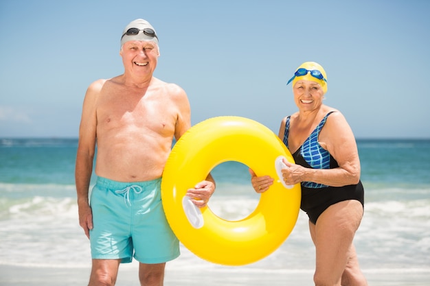 Hoger paar met zwemmende ring bij het strand