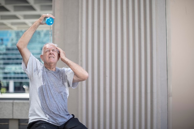 Hogere atleet die een pauze neemt en water over zijn hoofd giet