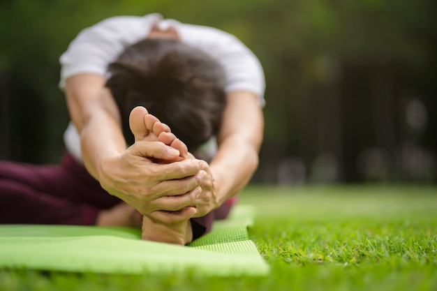 Hogere Aziatische vrouw het praktizeren yogaoefening openlucht in de ochtend. senior gezonde levensstijl