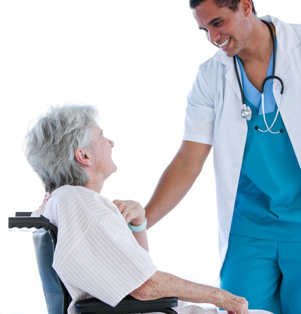 Hogere geduldige zitting op een rolstoel die met haar arts spreekt