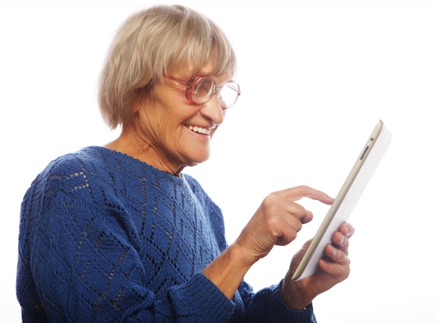 Hogere gelukkige vrouw die tablet gebruiken