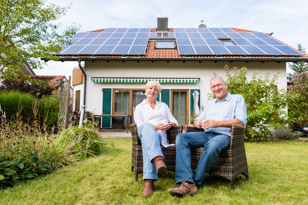 Hogere man en vrouwenzitting voor huis