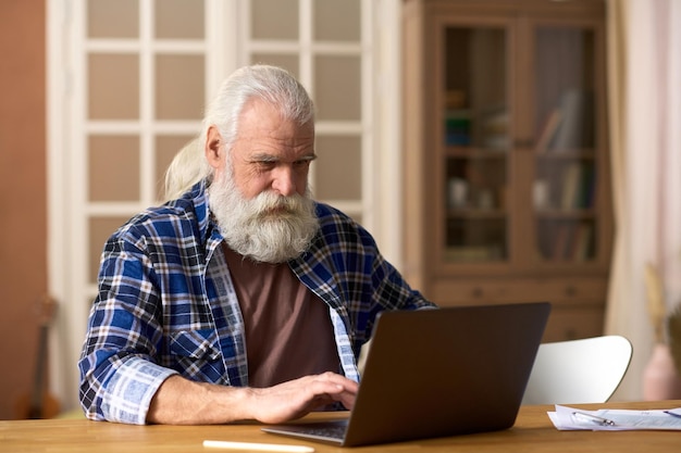 Hogere mens die online op laptop werkt
