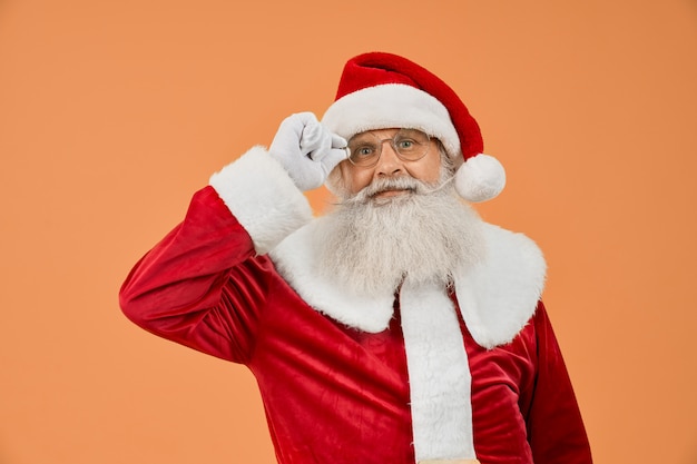 Hogere mens in rood Santa Claus-kostuum die zijn oogglazen dragen