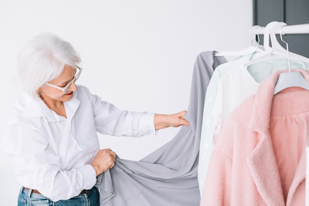 Hogere mode-stijl. Winkelen en kleding opties. Oudere dame die outfit kiest.