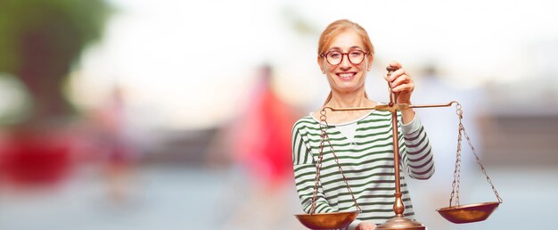 Hogere mooie vrouw met een rechtvaardigheidssaldo of een schaal