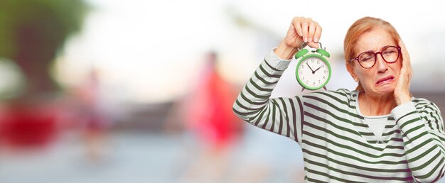 Foto hogere mooie vrouw met een wekker