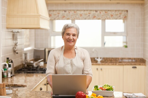 Hogere vrouw die aan haar laptop werkt