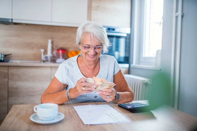 Hogere vrouw die financiën thuis doet.