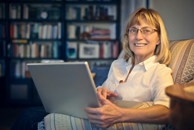 Hogere vrouw die laptop met behulp van