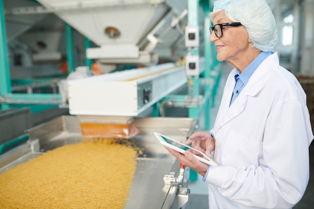 Hogere Vrouw die van het Werk genieten bij Fabriek