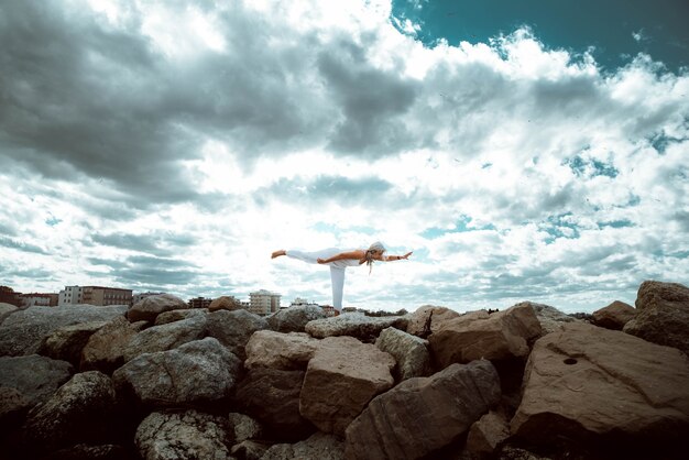 Hogere vrouw die yogaoefening doet bij strand