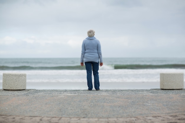 Hogere vrouw die zich op het strand bevindt