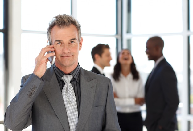 Hogere zakenman op telefoon in bureau