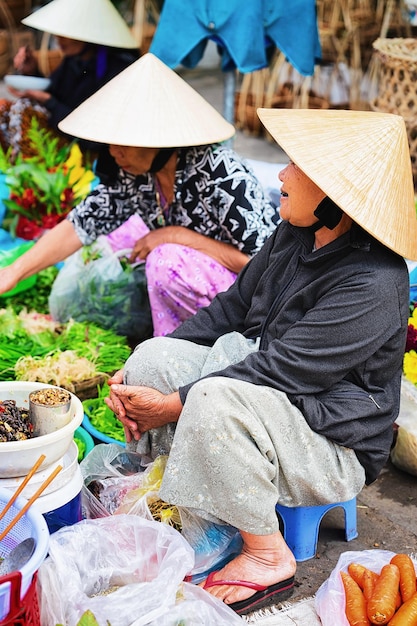 Hoi An, Vietnam - February 17, 2016: Woman vendor in the street market in old city of Hoi An, Vietnam