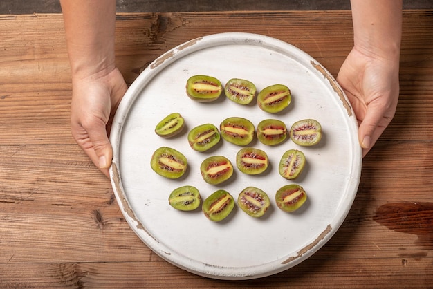 Photo hold the cut or whole kiwi fruit in your hand