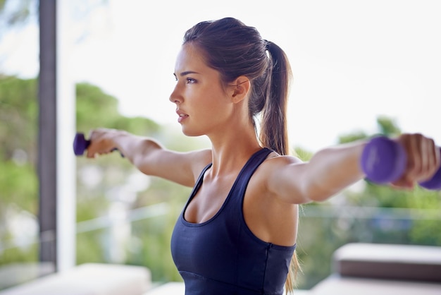 Hold it Shot van een aantrekkelijke jonge vrouw die traint met gewichten